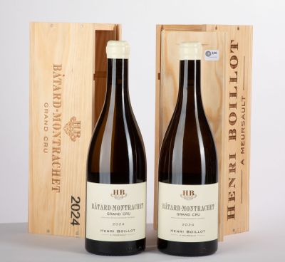 deux bouteilles de vin posées devant une caisse en bois sur une table