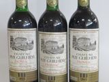 three bottles of red wine sitting next to each other on a table