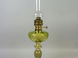 une image représentant une lampe en verre vert avec un pied doré