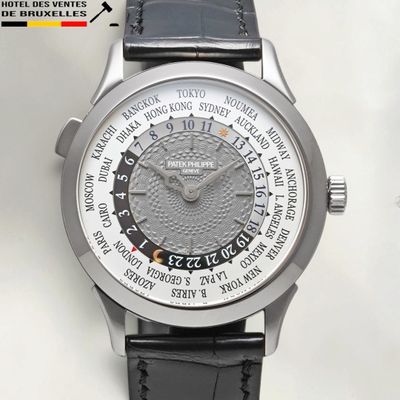 a close up of a watch on a white surface