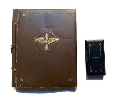 un vieux livre à la couverture en cuir posé à côté d'un livre orné d'un emblème représentant un avion