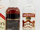 three bottles of liquor are lined up on a white surface