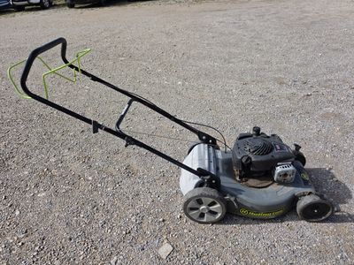 une tondeuse à gazon posée par terre sur un parking