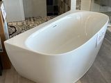 une baignoire blanche installée dans une salle de bains, à côté d'une douche à l'italienne