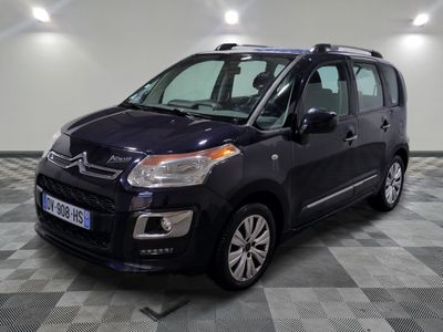 La petite camionnette noire est garée sur un sol en dalles à damier