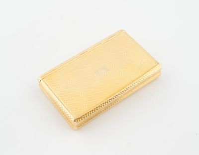 une image représentant un étui à cigarettes doré posé sur une surface blanche