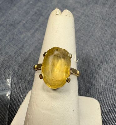 une image d'une bague ornée d'une pierre jaune