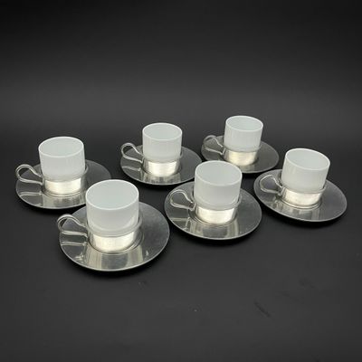 six tasses et soucoupes, posées sur une surface noire