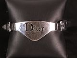 un gros plan d'un bracelet en argent sur lequel figure le mot « Dior »
