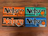 trois boîtes de bonbons « Nelson Nelson » posées sur une table en bois