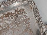 a silver tray that has a flower design on it