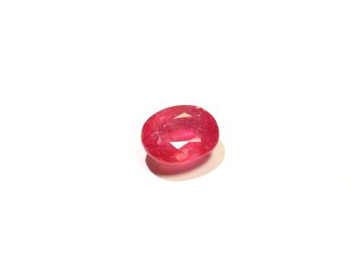 un gros plan d'un diamant rouge sur une surface blanche