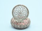 a small silver box with a flower design on top of it