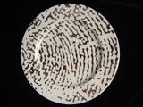 a white plate with a black and brown design on it