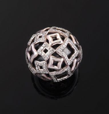une bague boule en or blanc et diamants sur un fond noir