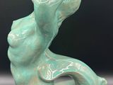 a green vase sitting on top of a table