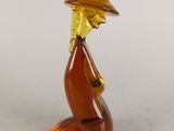 une image représentant une figurine en verre représentant une personne portant un chapeau