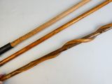 a person holding two wooden canes next to each other