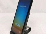 a close up of a phone on a stand on a white surface