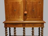 a wooden cabinet with two doors on top of it