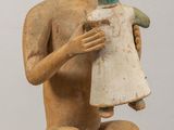 une image représentant une statue d'un homme tenant une poupée