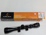 a close up of a rifle scope with a box on a table