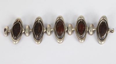 a group of five silver and garnet stone bracelets