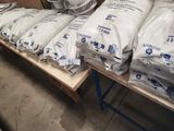 many bags of cement sitting on a table in a warehouse