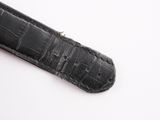 black leather watch strap with silver buckle on a white surface