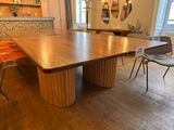 a large wooden table with chairs in a room