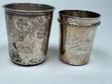 two silver cups sitting next to each other on a table