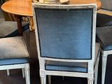 four chairs around a table with a vase of flowers on it