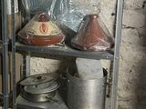many pots and pans sitting on a shelf in a room