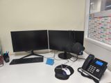 un bureau équipé de deux écrans, d'un clavier, d'un téléphone et d'un appareil téléphonique