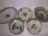 quatre assiettes à motifs différents posées sur une surface blanche