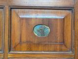 a close up of a wooden cabinet with a blue medallion on it