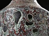 a close up of a vase with holes in it