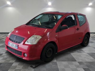 une petite voiture rouge garée dans un garage