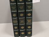 trois livres sont empilés sur une table