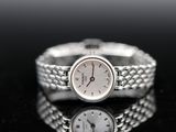 an image of a woman ' s wrist watch on a black surface