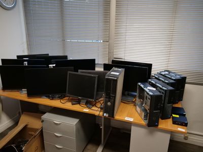 many computer monitors on the desk in this office