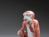 une petite figurine représentant un singe assis par terre