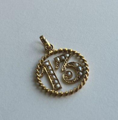 un gros plan d'un pendentif en or orné de perles
