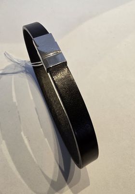 bracelet en cuir noir avec un fermoir argenté sur un fond blanc