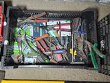 many different tools in a plastic container on the floor