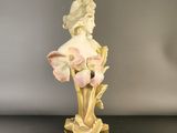 a statue of a woman with flowers on a table