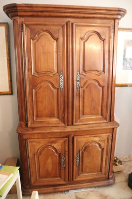 a large wooden armoire in the corner of a room