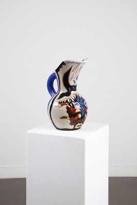 un vase en verre posé sur un socle blanc