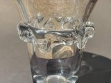 a glass vase with a handle on it on a table