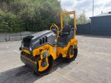 a close up of a yellow road roller sitting in a parking lot